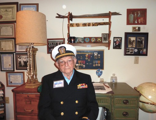 William E. Miller in his original Navy uniform, at his home filled with the accolades and 
mementos he collected during his service in World War II.