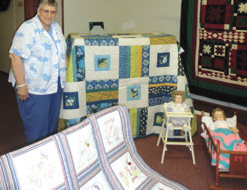 Lorena Jantz, president of Eden Mennonite Church’s Women in Mission, stands with quilts that will be auctioned at the Country Festival.