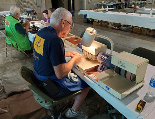 Ben Thomas sitting down polishing cabochons on the machine