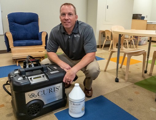 Chris Schultheis, M.S., Midwest Pathogend partner, demonstrates the CURIS fogging and newly invented spraying system in an early childhood education classroom at Lincoln Christian School, Tulsa, OK.