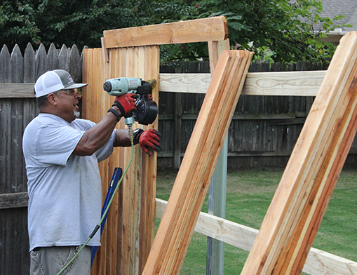 Employee Mike Acosta works on a fence near the 41st and Yale area.