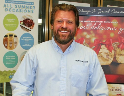 Honey Baked Ham of Tulsa Owner/Operator Lee Griffin with just a few of the delicious Holiday Gifts available at his Honey Baked store and cafe in Tulsa.