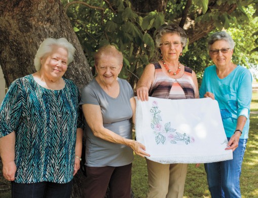 Members of Gamma Pi ESA hold the tablecloth that will be given at the 10th annual Bunco tournament.  (L to R) Carol Applegate, Janie Stevens, Kay Kirkes and Mary Adams.
