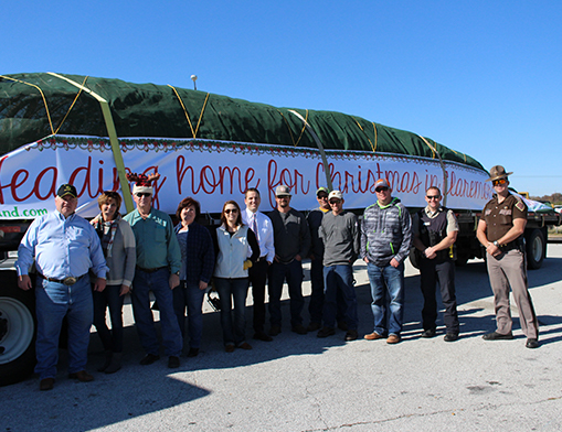 Picture from left to right are City Manager Jim Thomas, Tanya Andrews, Pelco Structural driver Joe, Kathy Thomas, Public Works Administrator with City of Claremore Jonah Humes, Lisa Rogers, employees of City of Miami Electric Department, and 2 OHP officers that helped escort the tree to Claremore.