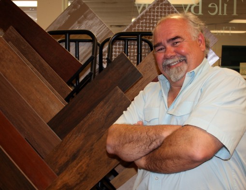 Tile by Tony owner Tony Sementi stands next to a showroom display featuring a few of his store’s new ceramic tile products in simulated wood patterns. 
Simulated wood designs are extremely popular in kitchen makeovers.