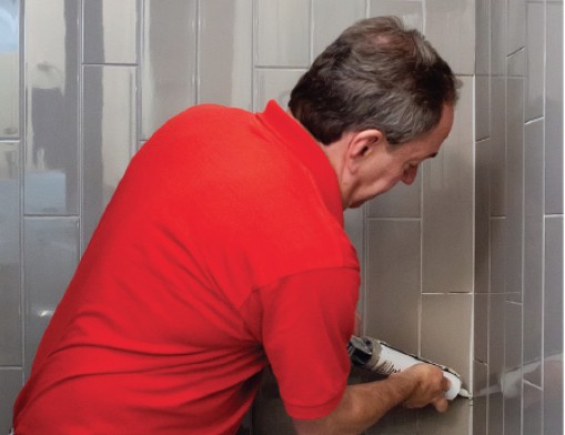 Kent Kantor, owner of Grout Care of Tulsa, re-seals the grout of a shower.