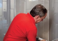 Kent Kantor, owner of Grout Care of Tulsa, re-seals the grout of a shower.