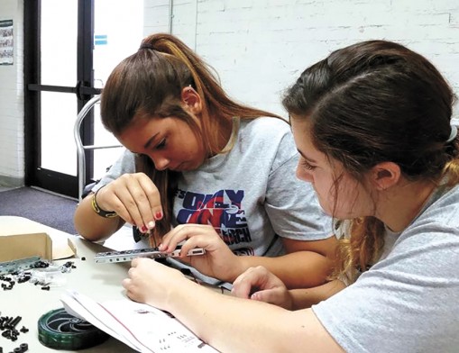 Skiatook High School students Sierra Shannon and Jaci Mashburn build a robot during a Talent Search camp at Rogers State University. The robotics lab is the result of a grant through AT&T Aspire. (Photo courtesy of RSU Talent Search.)