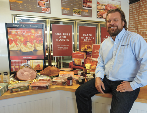 Lee Griffin, Owner/Operator of Honey Baked Ham Co. and Cafe of Tulsa, with just a tiny sample of the hams, turkeys and fixin’s available at Honey Baked Ham Co. and Cafe of Tulsa, located at 61st & Memorial.