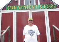 Farmer Jack stands in front of the “Corn”venient Store.