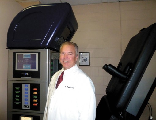 Dr. Craig Day stands in front of the DRX9000.
