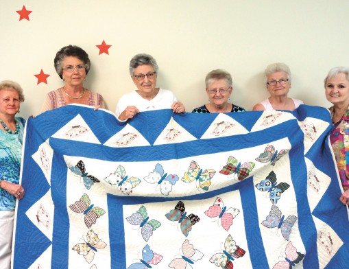 Members of Gamma Pi ESA hold the quilt that will be given at the 8th annual Bunco 
tournament. (L to R): Betty Mell, Kay Kirkes, Mary Adams, Janie Stevens, Gertrude Riddle, 
and Sue Johnston.