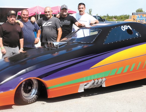 The MaeHem Racing Team poses with Rolling Thunder, a funny car ­dragster designed and hand-built over three and half years. The team ­consists of Paul Bridgewater, Michael Newman and family members, Mark DeMaro and his two nephews, Kris and Scott DeMauro. (Not pictured are driver David Summerton and crew members George Stabler, 
Will Summerton, and Scott DeMaro.)