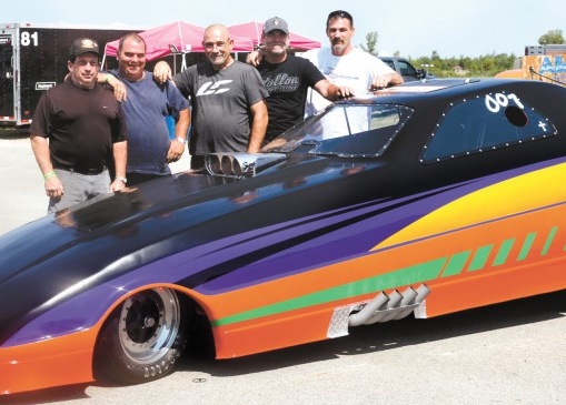 The MaeHem Racing Team poses with Rolling Thunder, a funny car ­dragster designed and hand-built over three and half years. The team ­consists of Paul Bridgewater, Michael Newman and family members, Mark DeMaro and his two nephews, Kris and Scott DeMauro. (Not pictured are driver David Summerton and crew members George Stabler, 
Will Summerton, and Scott DeMaro.)
