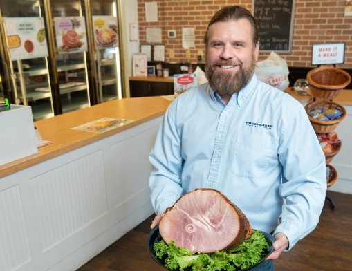 Lee Griffin, owner of Tulsa’s Honey Baked Ham store, with a spiral-cut bone-in half halm.