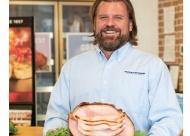 Lee Griffin, owner of Tulsa’s Honey Baked Ham store, with a spiral-cut bone-in half halm.