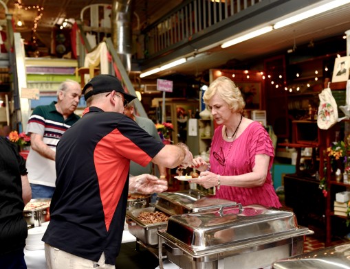 Claremore Elks Catering gives out samples to attendees inside Sailor Antiques during the 2015 Sip, Savor & Shop: Taste of Claremore.