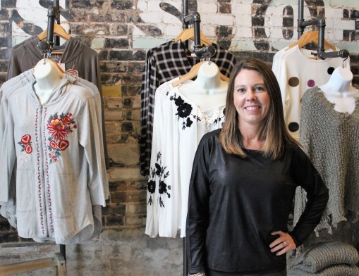 District owner Cari Bohannan showcases new fall clothing arrivals.
