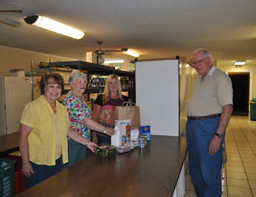 Volunteers (l to r) Gail Norton,  Pat Taft, Mindy Mullins and Joe Henry (opposite side of counter) volunteer at the food pantry.