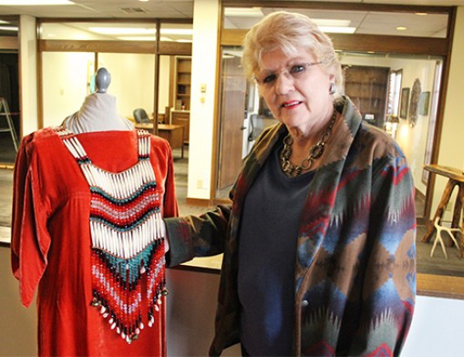 Betsy Swimmer appreciates an authentic Native American dress, made by one of the artists whose work will be on display at the Vault Gallery in Catoosa.