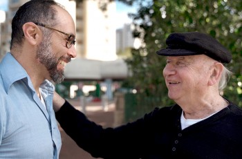 American filmmaker Yoav Potash, left, greets Holocaust survivor Yaacov Goldstein in the documentary &ldquo;Among Neighbors.&rdquo; Courtesy of Headfirst Arts and Media