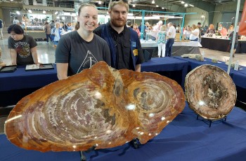 Brittany Pepper and Peter Grice behind the big petrified wood slabs