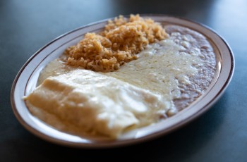 Enchiladas served with refried beans, Mexican rice and El Maguey's signature white sauce.