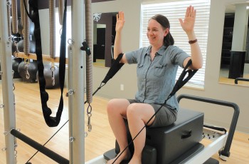 Beth West demonstrates the Pilates Reformer machine.