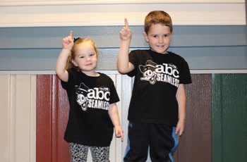 Future steel roofing and siding cuties have a little fun in front of one of the showroom sample walls.