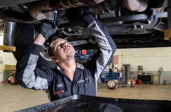 Route 66 Chevrolet master technician Willie inspects the undercarraige of a vehicle.