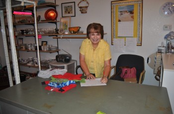 Gail Norton, Volunteer, handles the check out at GSM Thrift Store.