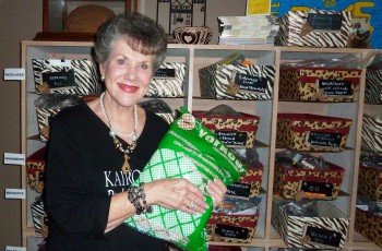 Leah Horner holds a mosquito net in front of the “tagged and bagged” Kairos 10 jewelry.