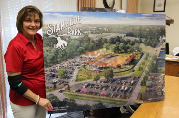 VisitClaremore director Tanya Andrews with a rendering of Stampede Park, where the Will Rogers Stampede PRCA Rodeo will be returning this year.