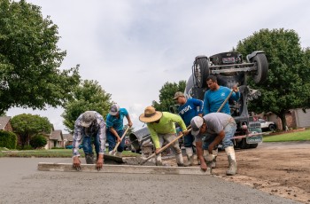 The LCI Concrete team levels out fresh concrete on a driveway replacement.