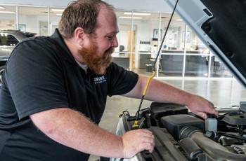 Cody Cox does a visual inspection under the hood of a customer’s Jeep.