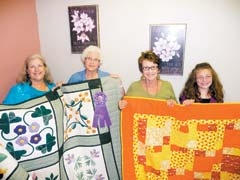 (L to R): Rosalie Peterson, HCE Quilt Show co-chair; Merla Gilbert, with her 2009 “Grand Champion” quilt; Debby Presley, Quilt Show co-chair; and Victoria Teale, age 11, with her 2009 entry quilt.