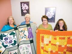 (L to R): Rosalie Peterson, HCE Quilt Show co-chair; Merla Gilbert, with her 2009 “Grand Champion” quilt; Debby Presley, Quilt Show co-chair; and Victoria Teale, age 11, with her 2009 entry quilt.