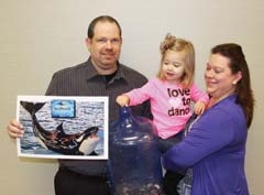 Motivation to save. RCB Bank employee Sarah Smith, of Pryor, says her family saves money by putting all their coins in a jar, which they will use to fund their upcoming vacation to Sea World.