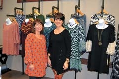 Cari Bohannan (left) and Katrina Pope stand in front of 
some of the new spring dresses available at The District 
on Main in Claremore.