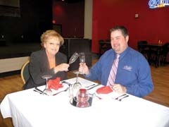 Sue Hammons and Kelly Cathey toast with the commemorative wine glasses that diners will receive at the Valentine’s Day Dinner at Cherokee Casino Will Rogers Downs.