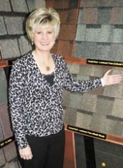 Judy Smith, sales and marketing director, shows various selections of roofing shingles in the showroom at A-Best Roofing.