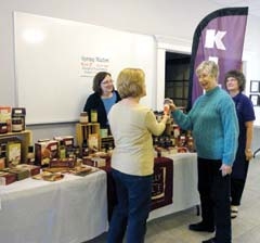 Members of Servants of the King Lutheran Women’s ­Missionary League check out food mixes and sauces from Tastefully Simple. (L to R): Lori Knoepfel (behind the table), Pat Bartley, Krystine Gibson, and Vicki Wing.