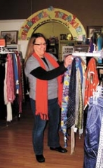 Mary Baumgardner, one of the shift store managers, arranges scarves on a display at Thrift Harbor.