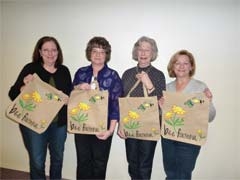 Members of Servants of the King, with the free tote bags to be given to the first 200 families at their Spring Market. (L to R): Lori Knoepfel, Vicki Wing, Krystine Gibson and Pat Bartley.