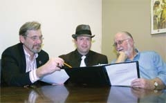 Playwright Mark Ogle (left) and play director Dan Huey (right) go over Ogle’s latest script, “The Butler Did It,” with David Barron, who will be portraying a crime boss in the murder mystery fundraiser.