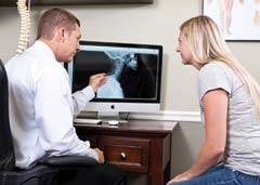 Dr. Jason Schluter explains results of an X-ray analysis to a patient.