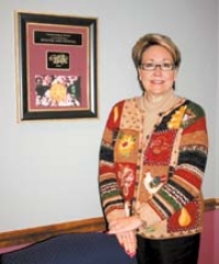 Kathy Reynolds, vice president of programs for the Broken Arrow Area Chamber of Commerce, shows off the RedBud Outstanding Event Award presented by the Governor of Oklahoma in recognition of the 2009 Rooster Days festival.