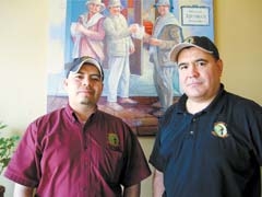 Cook Miguel and owner Gerardo Barbosa stand in front of a painting of them and Francisco Barbosa at Tijuana’s Grill &amp; Cantina.