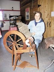 Diane spins a shawl at the spinning wheel.