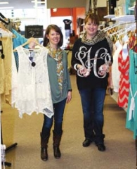 Nesting Necessities &amp; Boutique owners Cari Bohannan and Susan Todd display some of their merchandise available, including this trendy top and a monogram that can be used to decorate your bedroom or any other wall in your house.